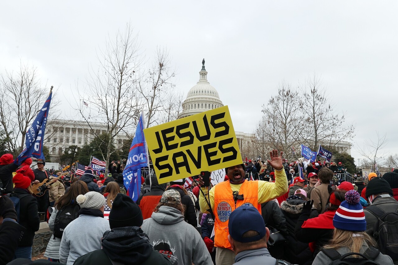 ▲ 2021년 1월 6일, 미국 의사당 앞에서 ‘JESUS SAVES’(예수는 구원하신다) 피켓을 든 참가자가 트럼프 지지 시위에 참여하고 있다. 이 날의 폭력 사태는 ‘기독교 민족주의’와 정치적 극단주의가 결합한 대표적 장면으로 기록된다. ⓒNPR